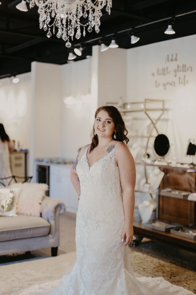 Woman wearing a lace plus size wedding gown in wedding shoppe berkley mi