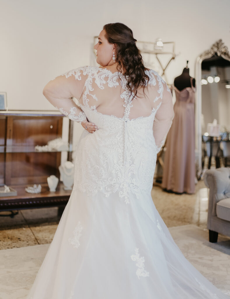 Back of woman wearing a plus size mermaid cut bridal gown with sleeves the wedding shoppe berkley