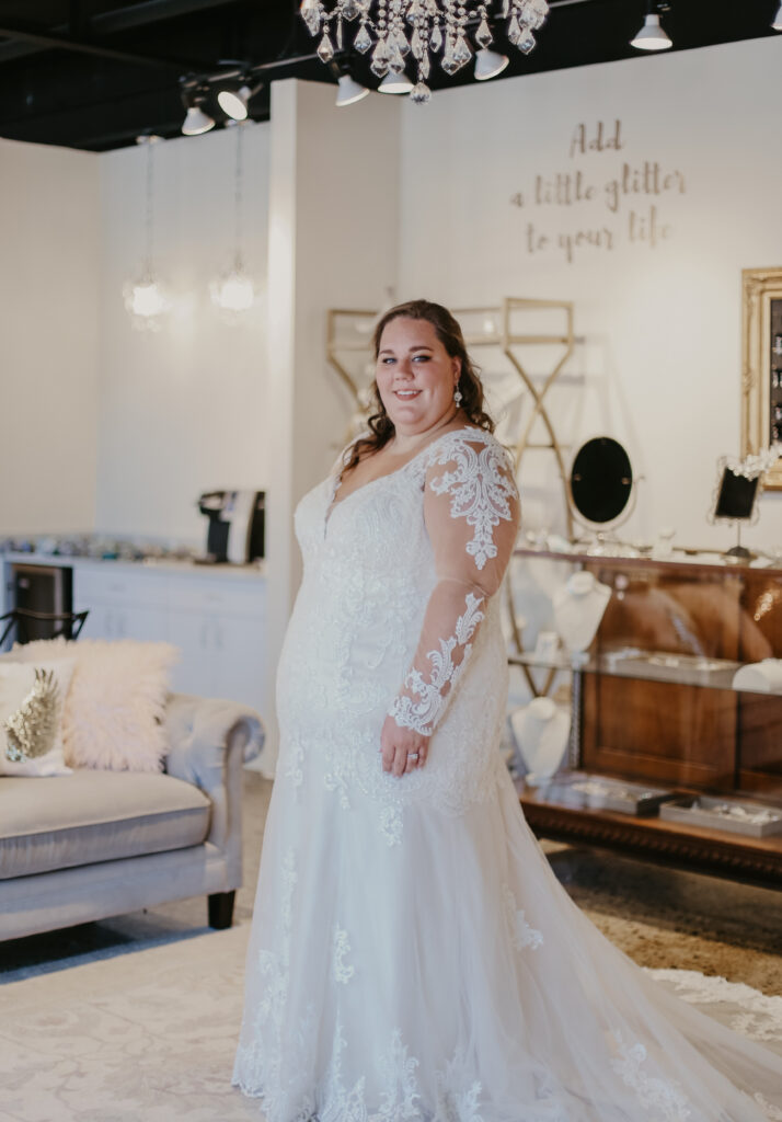 Woman wearing a plus size wedding dress with intricate sleeve details bridal shops in berkley mi