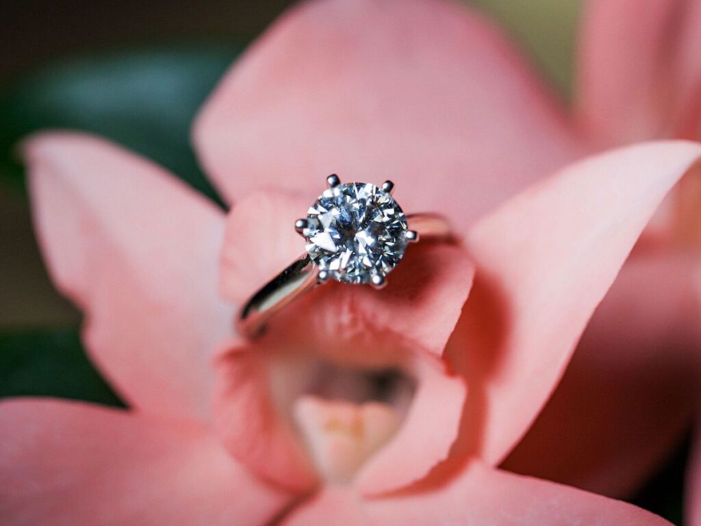 engagement ring on pink flower background