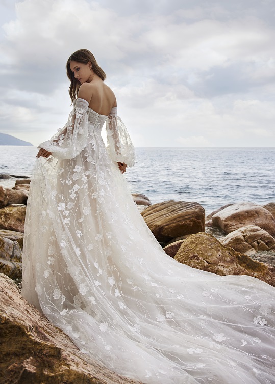 woman standing near ocean in lace bridal gown