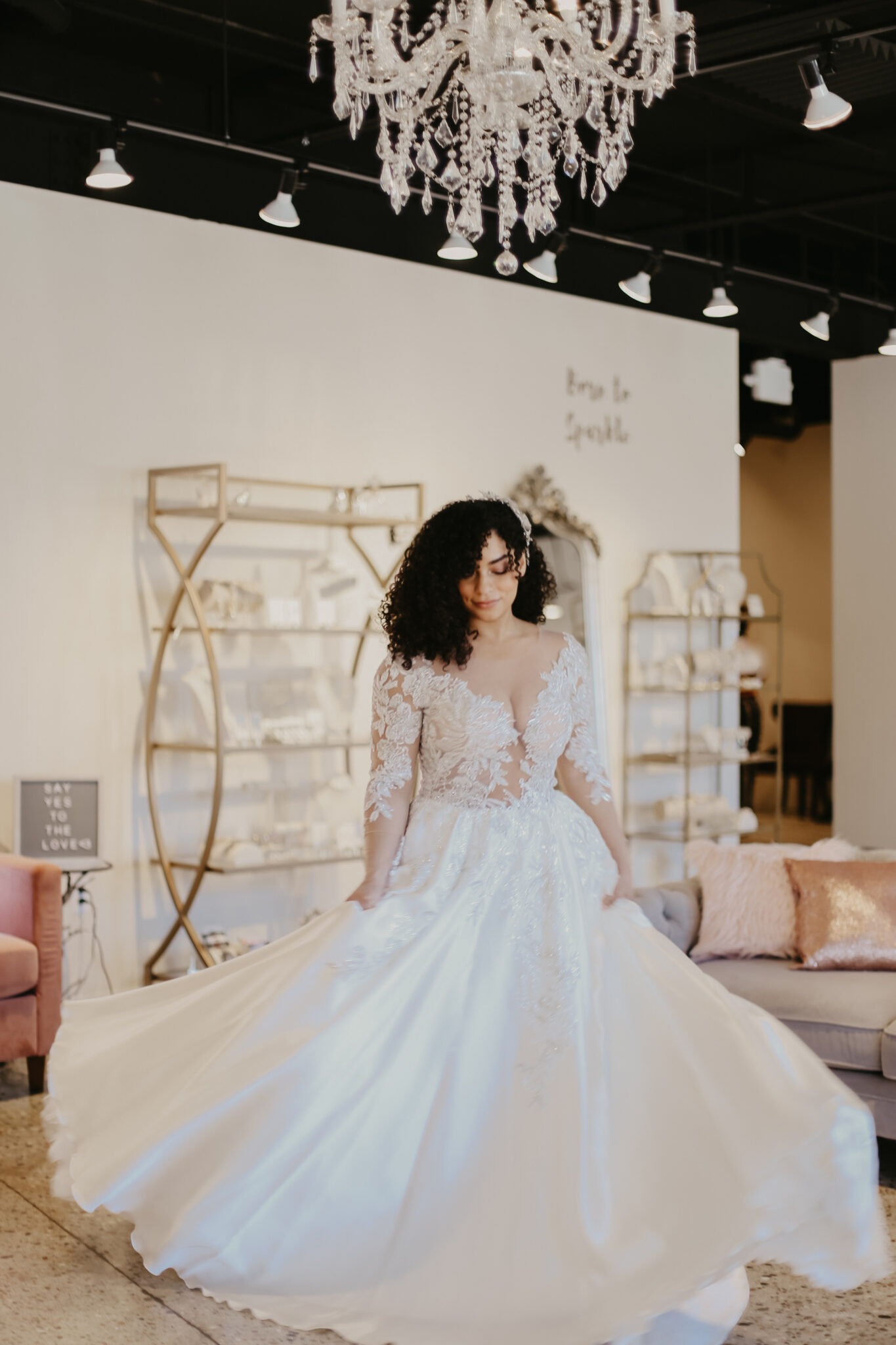 bride in bridal store in wedding gown with laced, deep-vee top