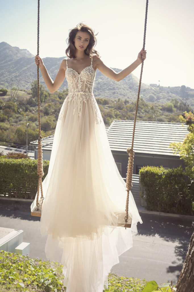 Woman in wedding dress standing on a swing