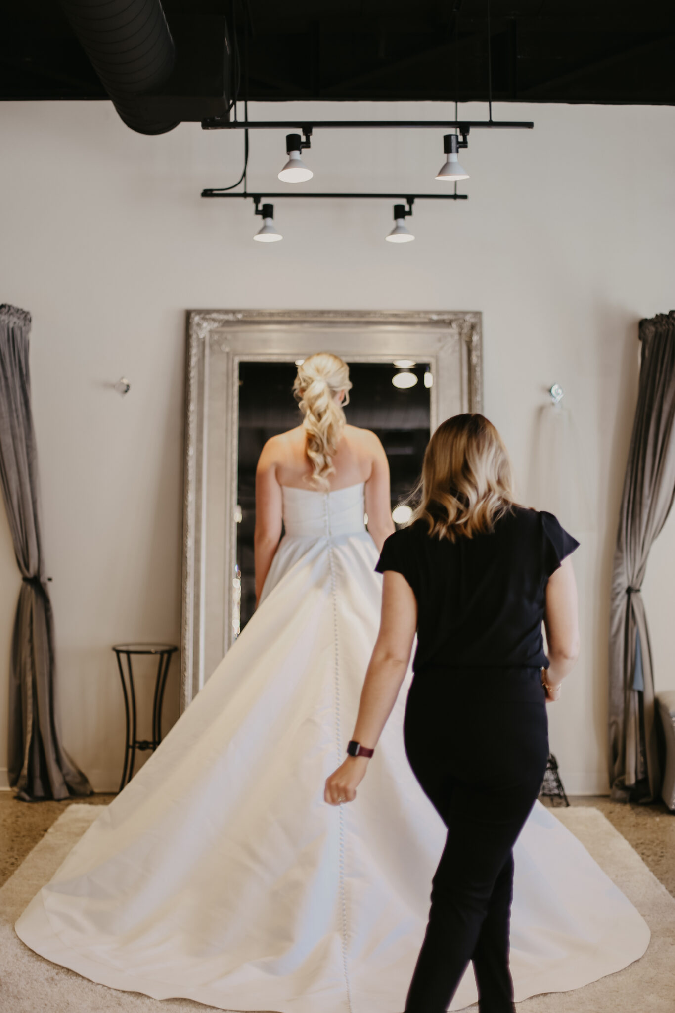 woman looking in mirror to see how new wedding dress fits