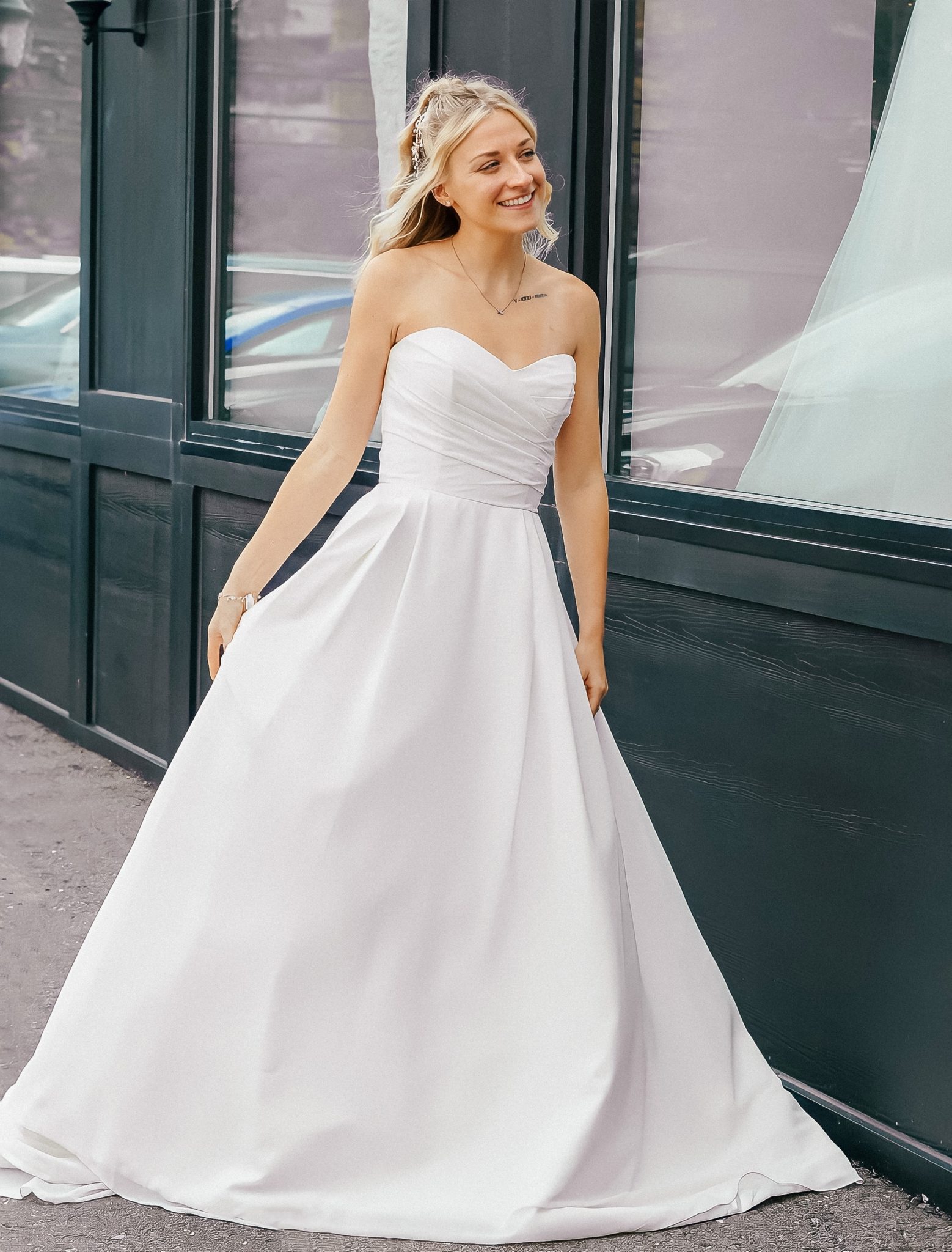 shot of woman outside store in white a line wedding dress