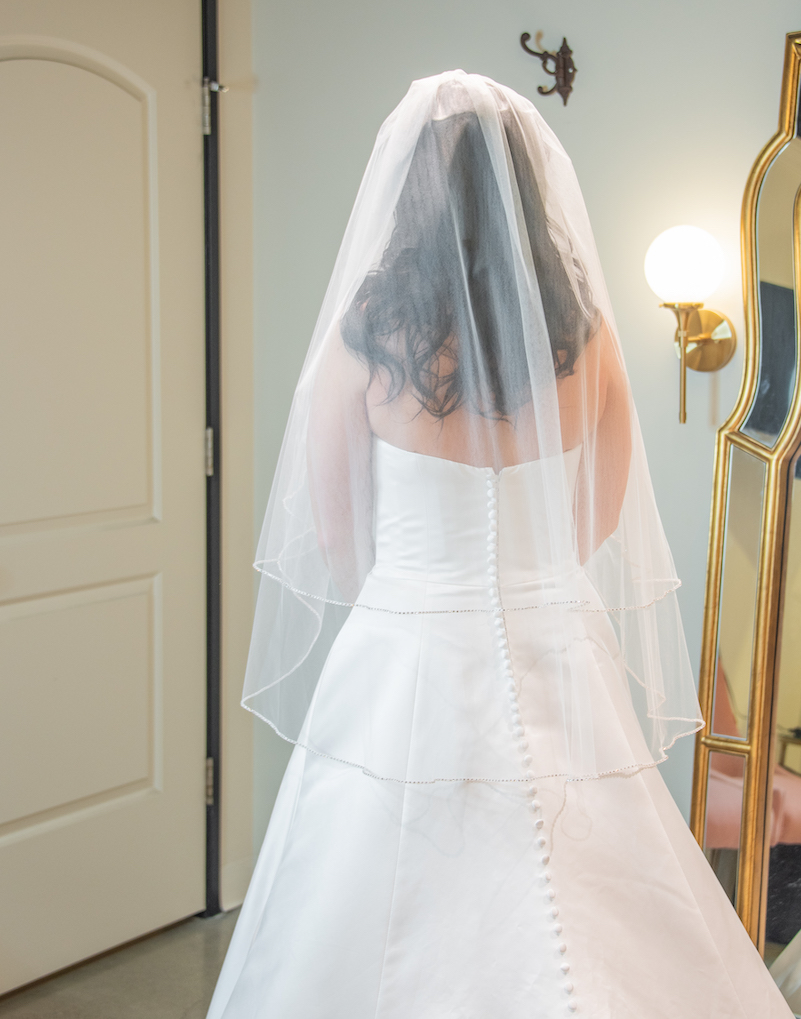 A woman in a bridal dress with her back to the camera