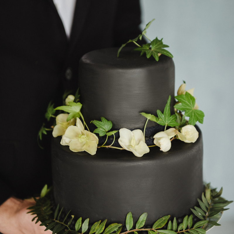 dark wedding cake with leaves placed on tiers