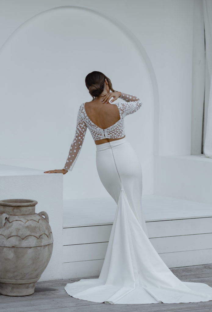 back of woman wearing see-through bridal top and sheath skirt