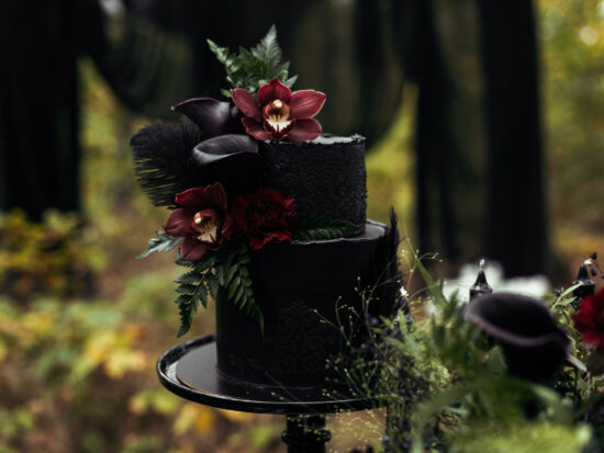 A unique and beautiful dark wedding cake with flowers.