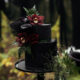 A unique and beautiful dark wedding cake with flowers.