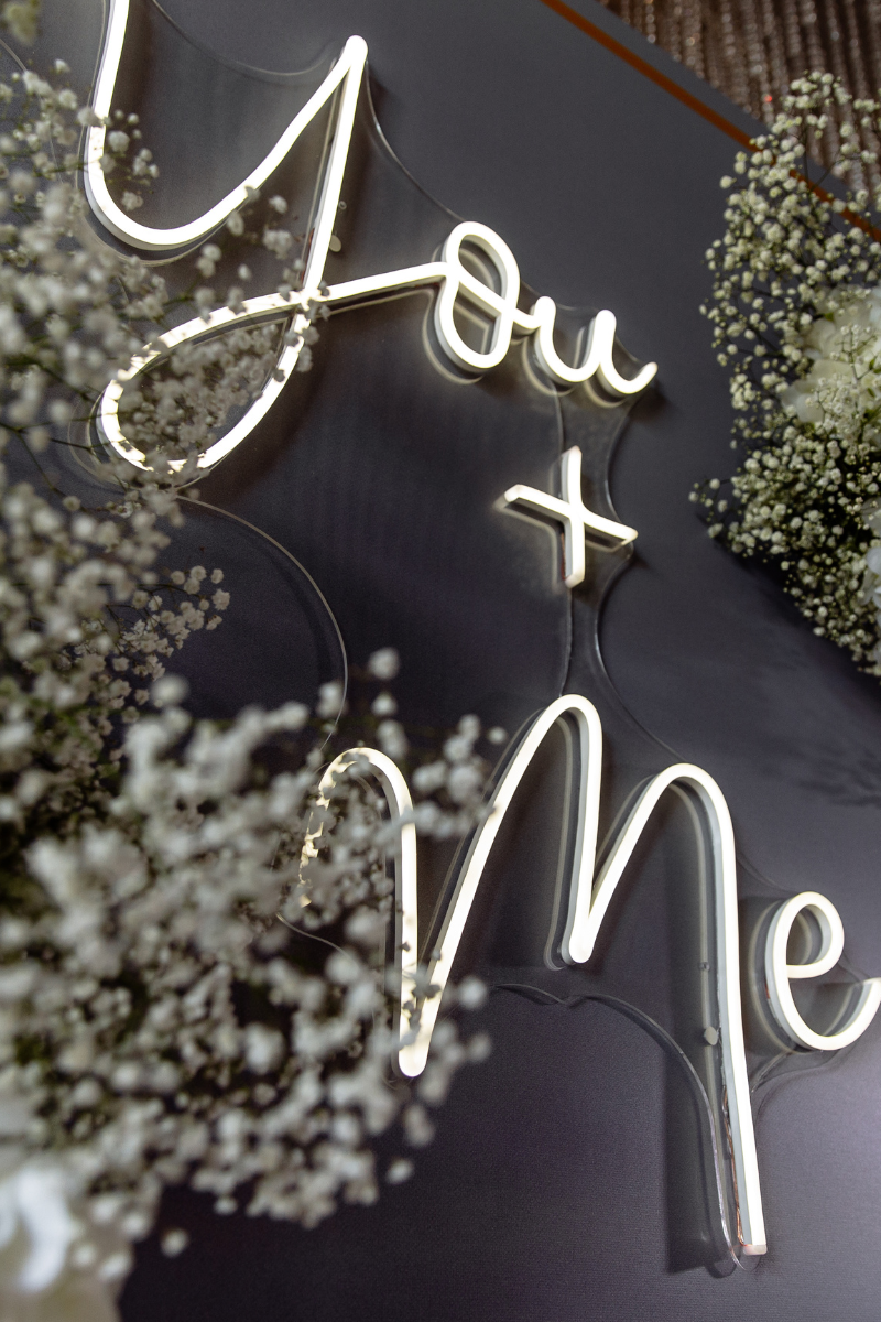 large white neon sign spelling out "You + Me"