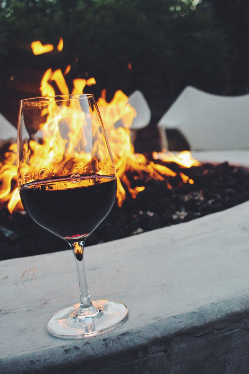 glass of red wine placed on edge of fireplace