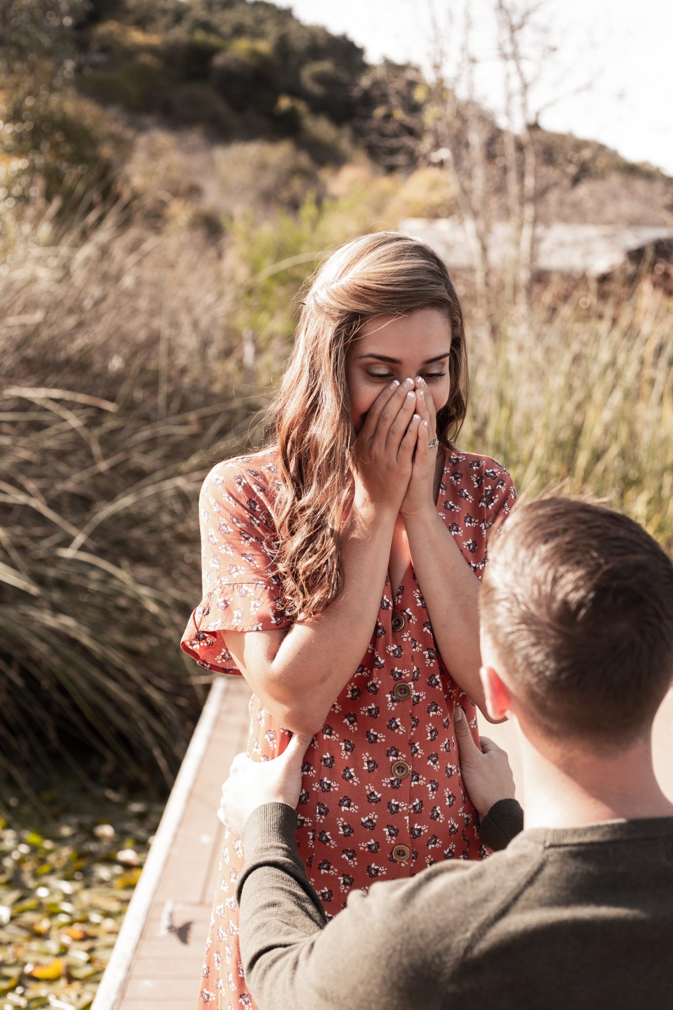 man proposing to woman in grassy park