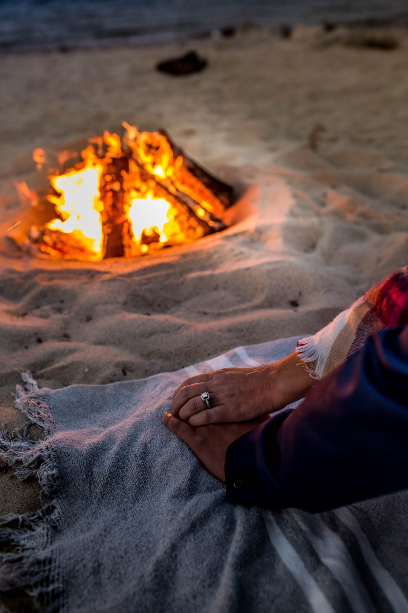 woman and man relaxing near beach fire