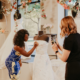 bridal stylist taking picture of bride to be signing wedding dress