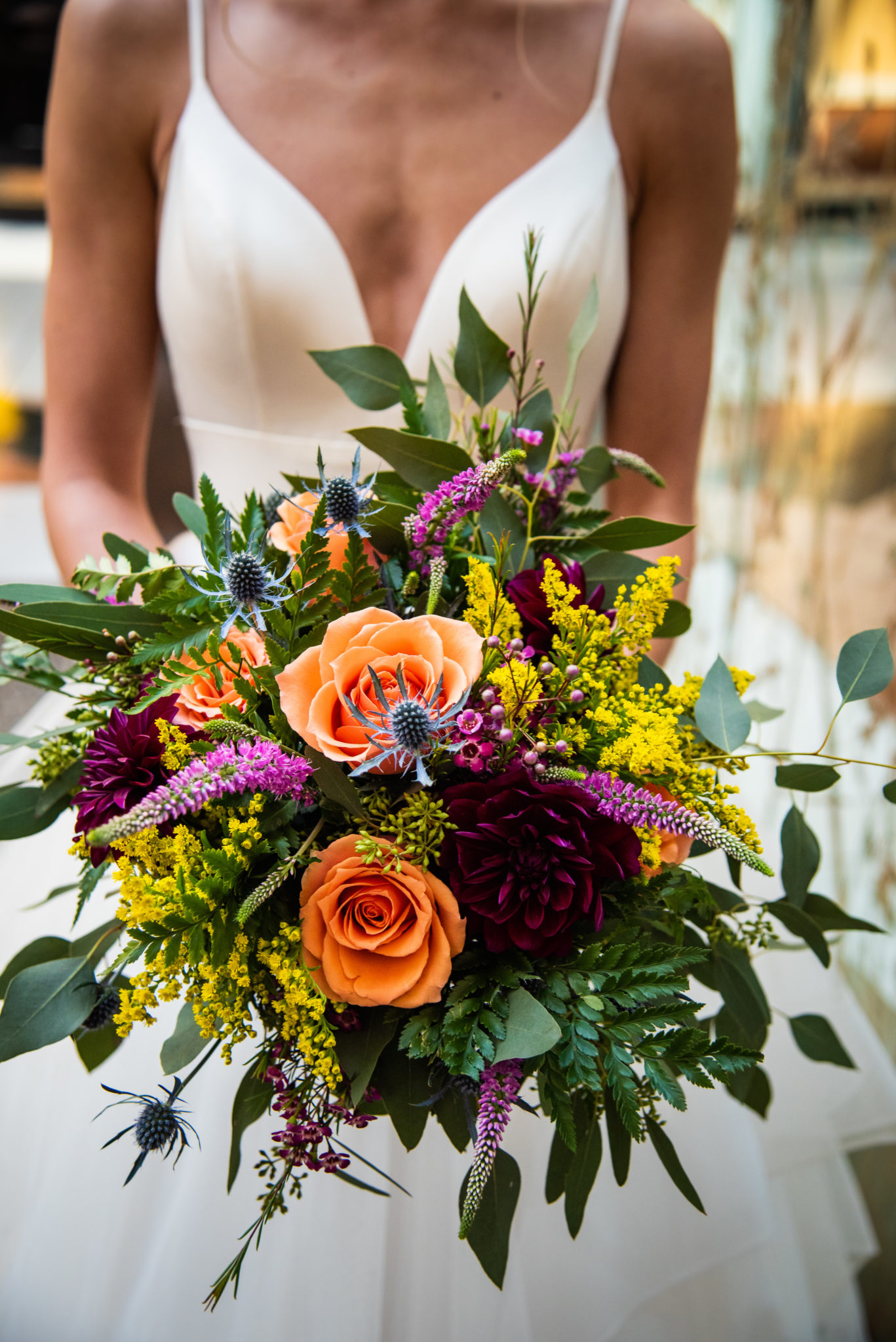 bride holding bright, colorful bouquet of flowers