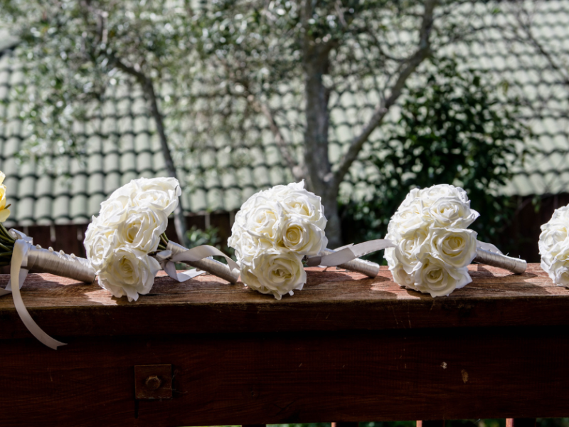 5 bouquets of flowers resting on wood