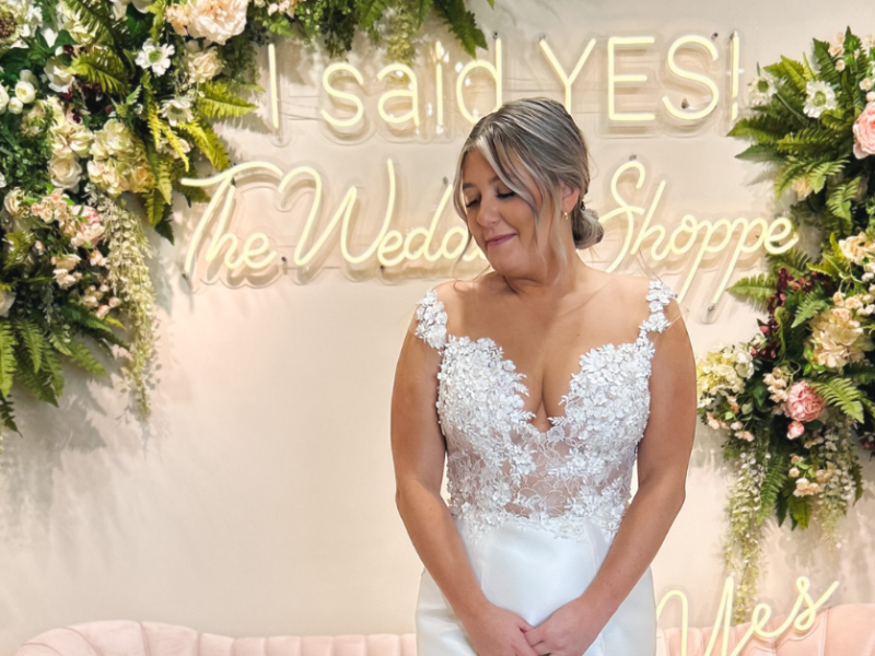 bride in wedding dress in front of neon light display