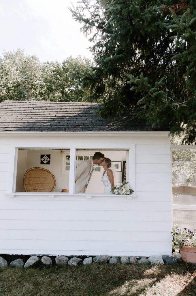 married couple kissing in small white house at Cherry Basket Farm