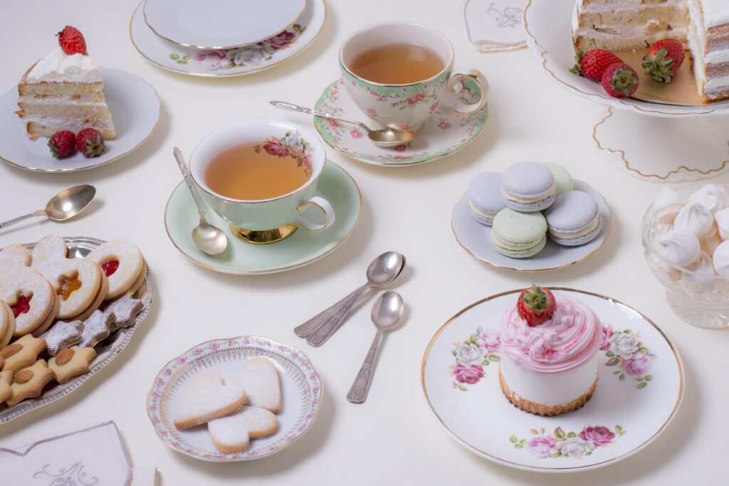tea party spread with tea and sweets on floral plates