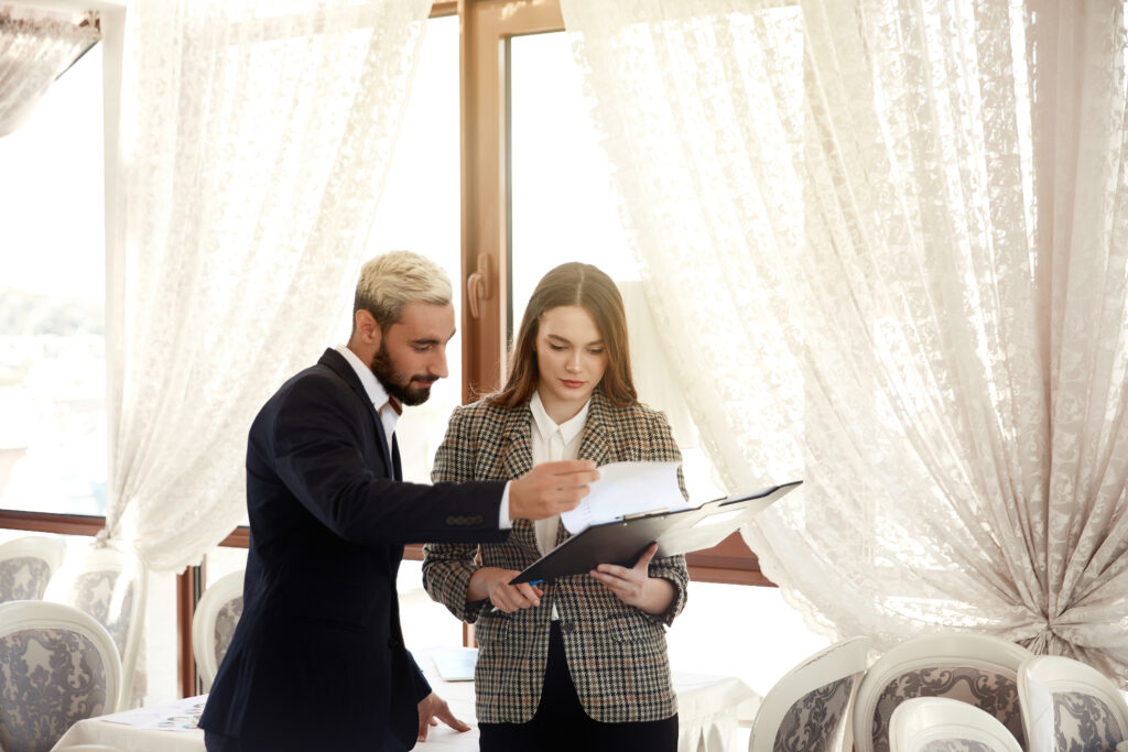 man and a woman looking at a clipboard to plan a bridal shower