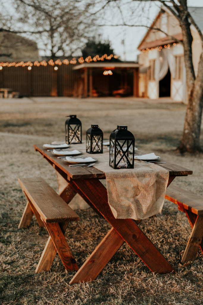 rustic wood table with rustic tablecloth and lanterns for a forest wedding reception