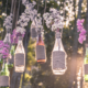 personalized decor hanging bottles with white and pink flowers in trees