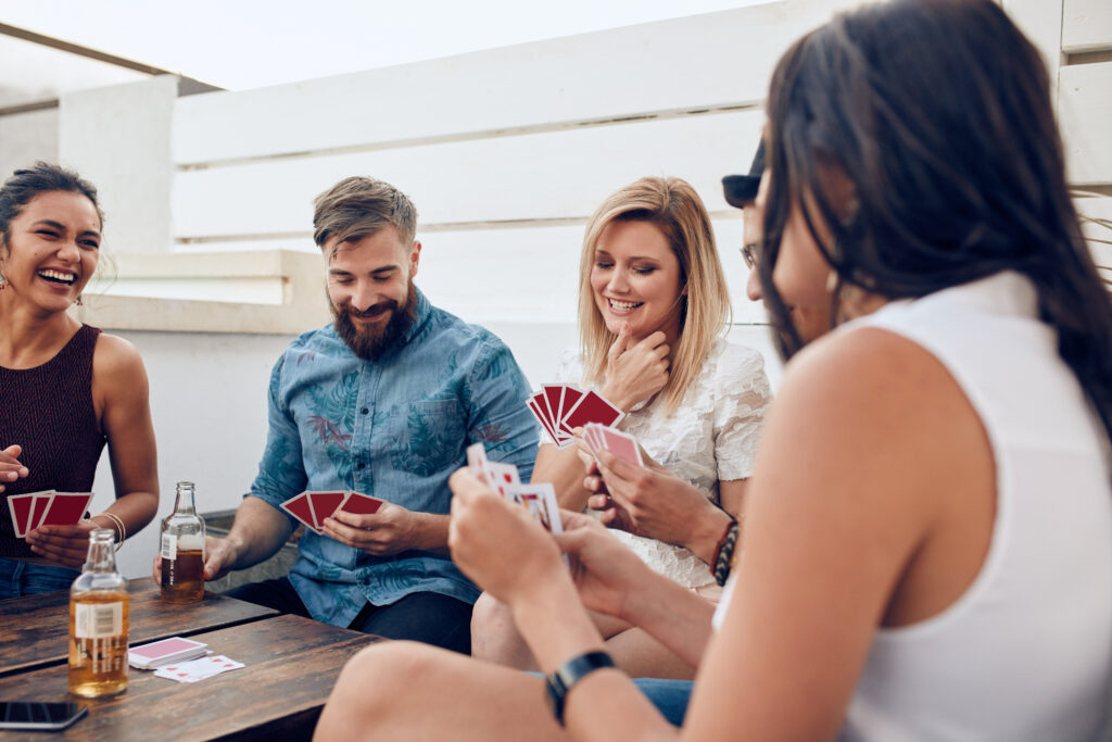 people playing cards and having drinks at a wedding rehearsal dinner