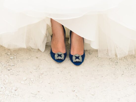 blue shoes peeking out from underneath a gorgeous wedding dress
