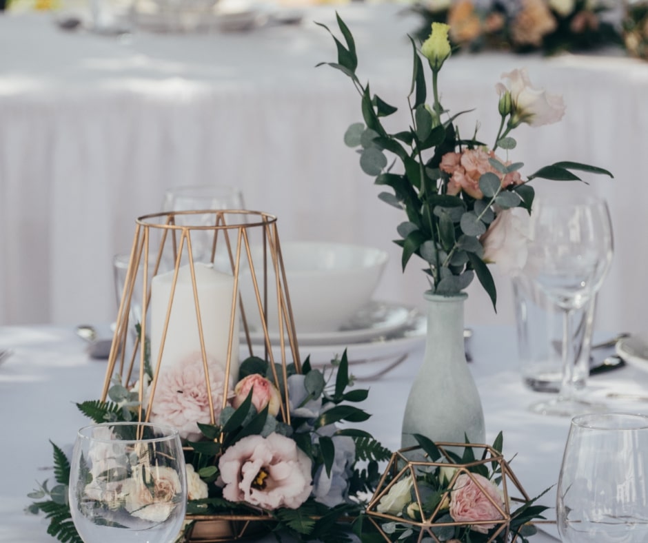 modern elegant decor for a wedding with geometric candle holders and a vase with tasteful flowers