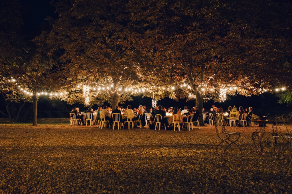 beautiful wedding underneath trees lit with hanging lights