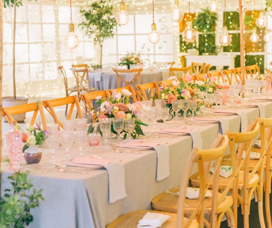 dining table set up with flowers and colorful accents with hanging lights above