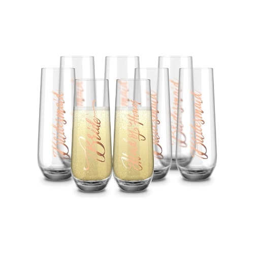Set of clear, glass crystal, stemless flutes. On the side of each flute is "Bride" or "Bridesmaid" in rose gold.
