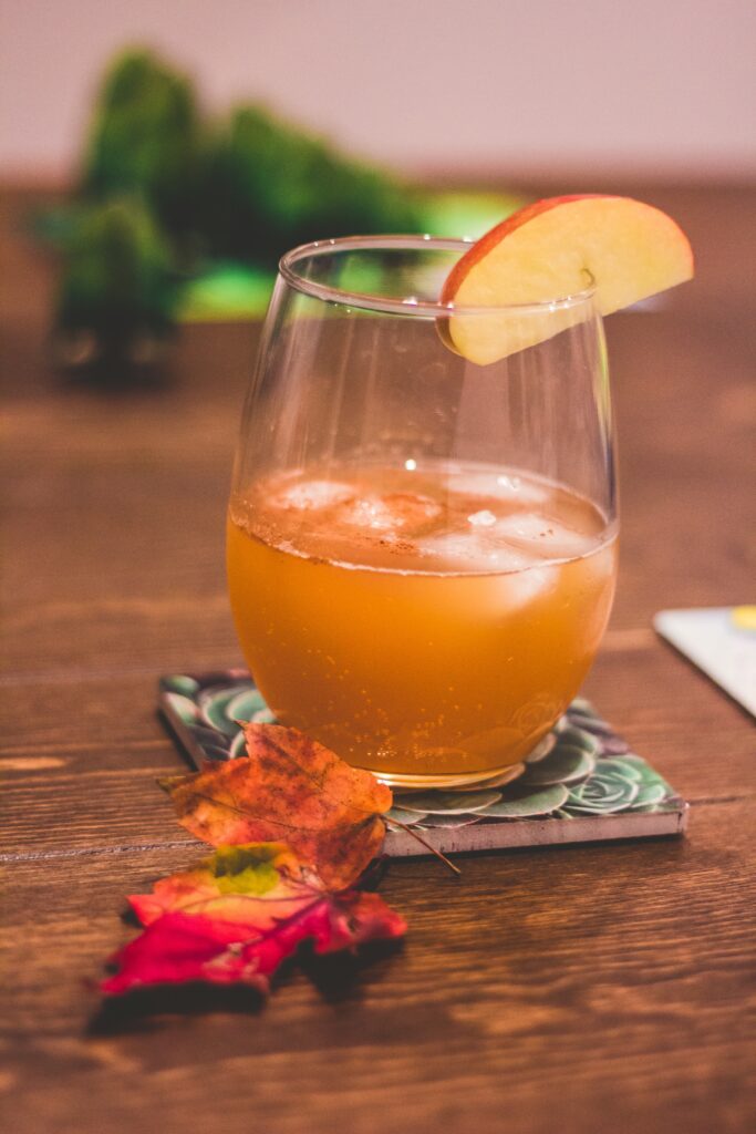 cider drink with two red leaves and an apple slice for a fall wedding