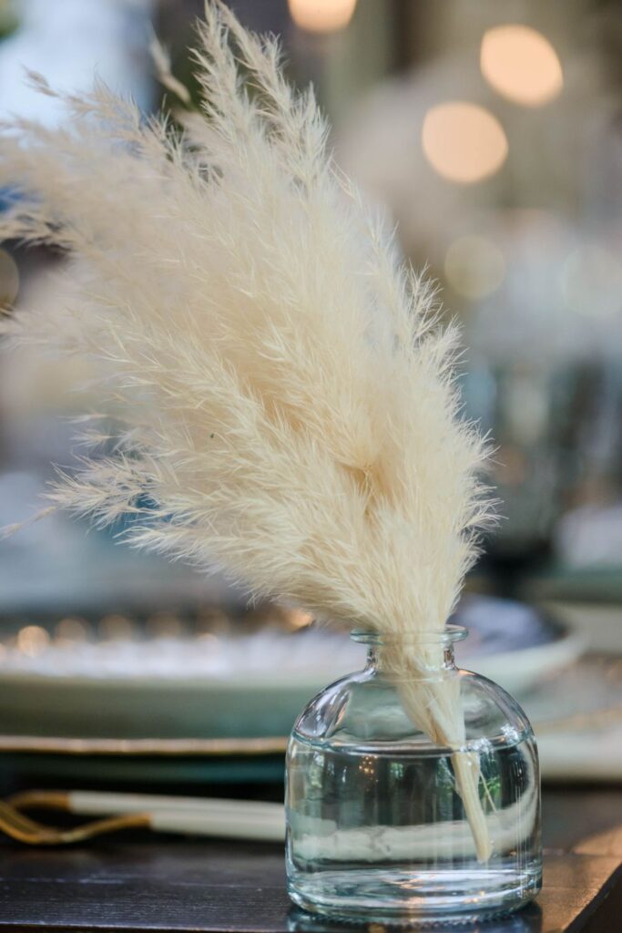 white feathers in a small jar for a gatsby-themed wedding