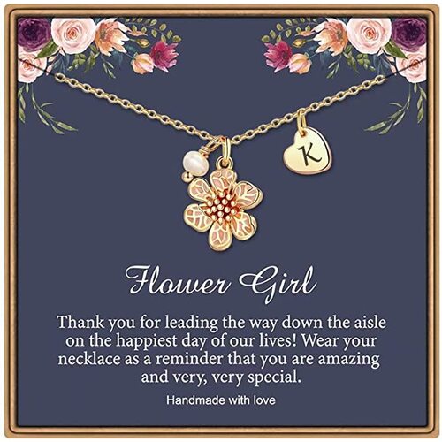 A small golden chain necklace with an enamel flower charm and initial charm.