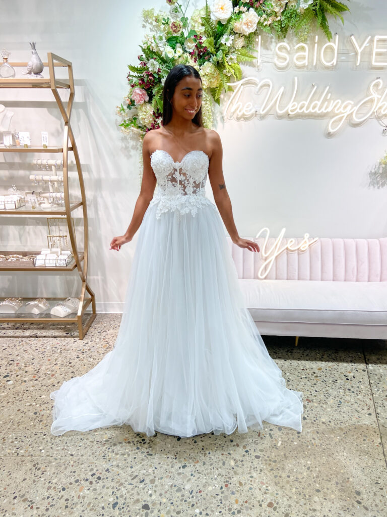 Bride wearing sweetheart neckline with lace accents on the bodice, the skirt is a tulle, floor length train.