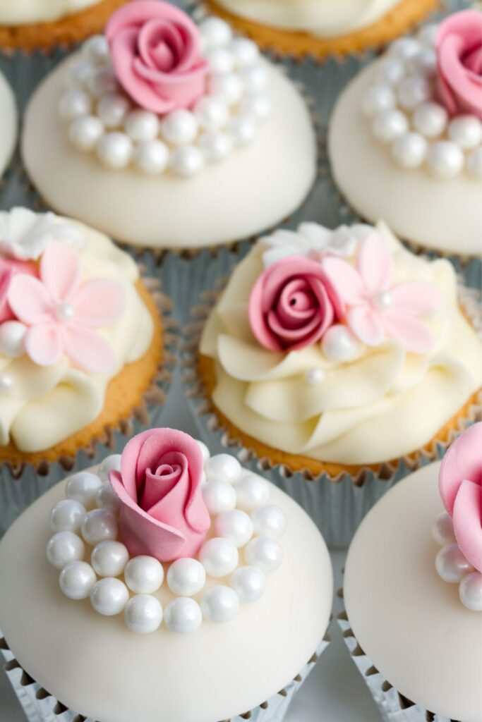 cupcakes topped with roses and small pearls for a gatsby-themed wedding