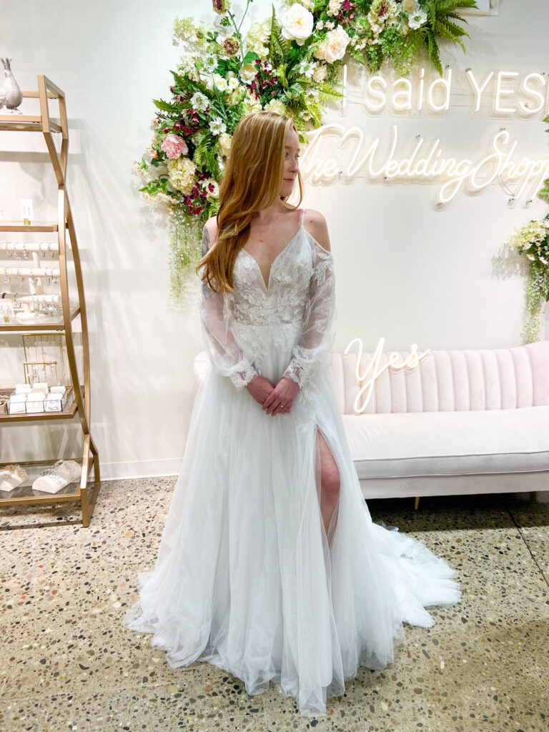 Gorgeous The Wedding Shoppe bride wearing gown with shoulder keyhole cutouts and slit up the tulle lace skirt.