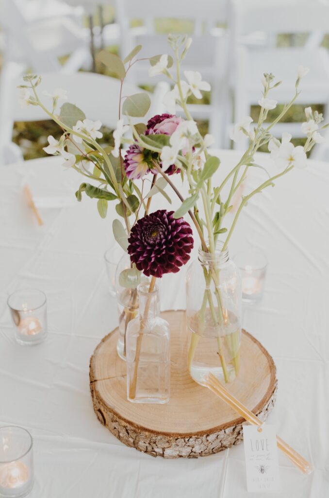 a floral centerpiece with white and purple flowers perfect for an outdoor fall wedding
