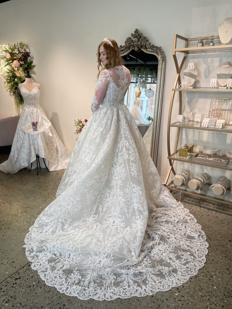 Tate by Rivini is a gorgeous ballgown with traditional lace modest neckline.