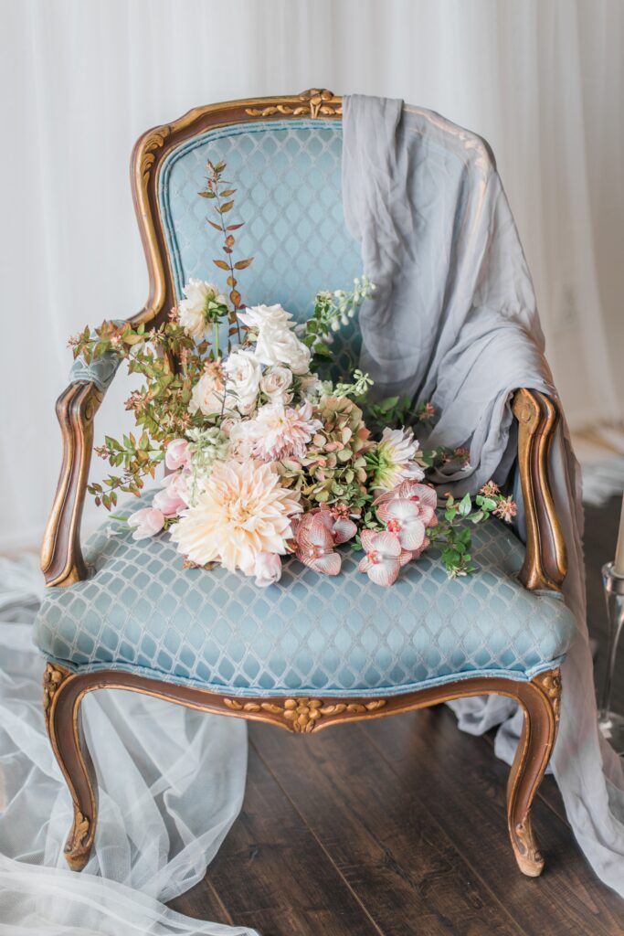 velvet seat with blue fabric and flowers and a draped lace design for a Victorian wedding