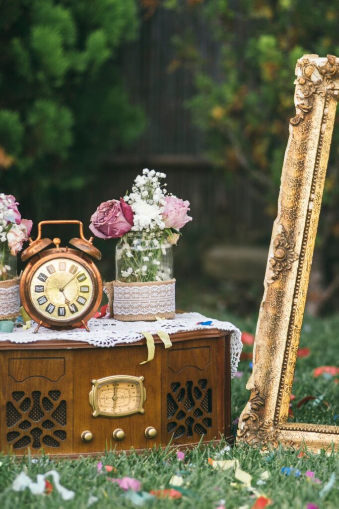 vintage props for a Victorian wedding like a mirror and mason jars with flowers and an old-timey radio