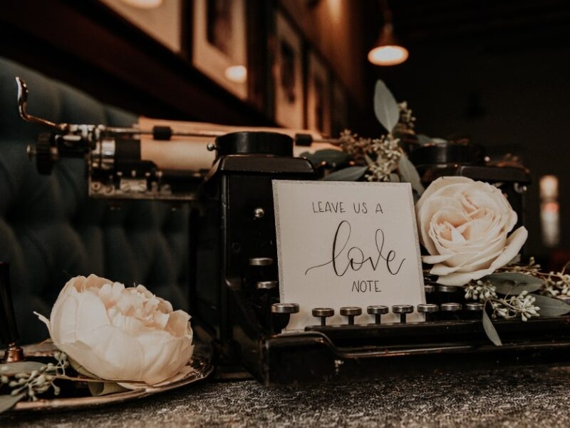old typewriter as vintage wedding decor with a card that says "leave us a love note"