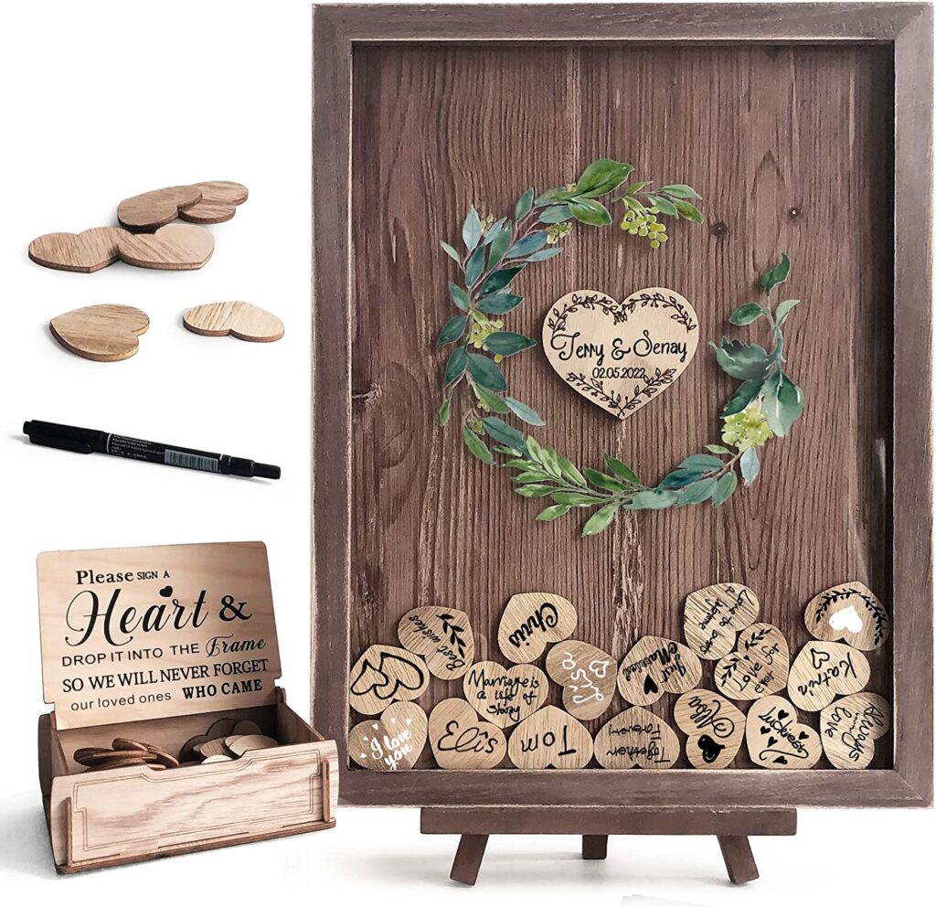 Wooden wedding shadowbox with small little hearts dropped inside. On the wooden hearts are names written by guests of the wedding.