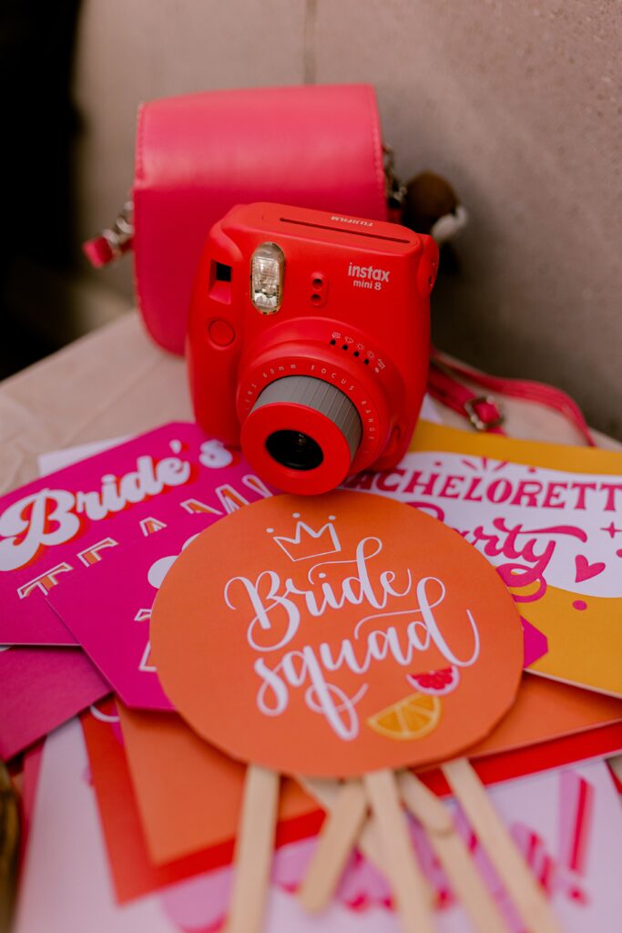 retro themed bridal shower with old polaroid cameras and a sign that says "Bride Squad"