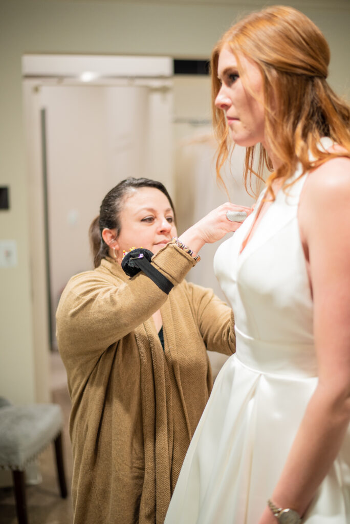 Bride-to-Be in her alterations appointment wearing her gown and getting measured by her alterations specialist.