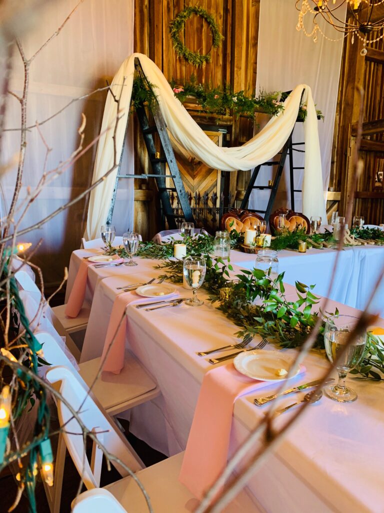wedding table set up with green foliage and rustic ambiance