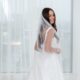 bride wearing a wedding dress and a white pearl veil as her "something borrowed"