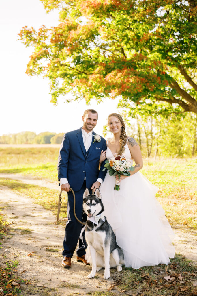 couple on their wedding day with their husky dog